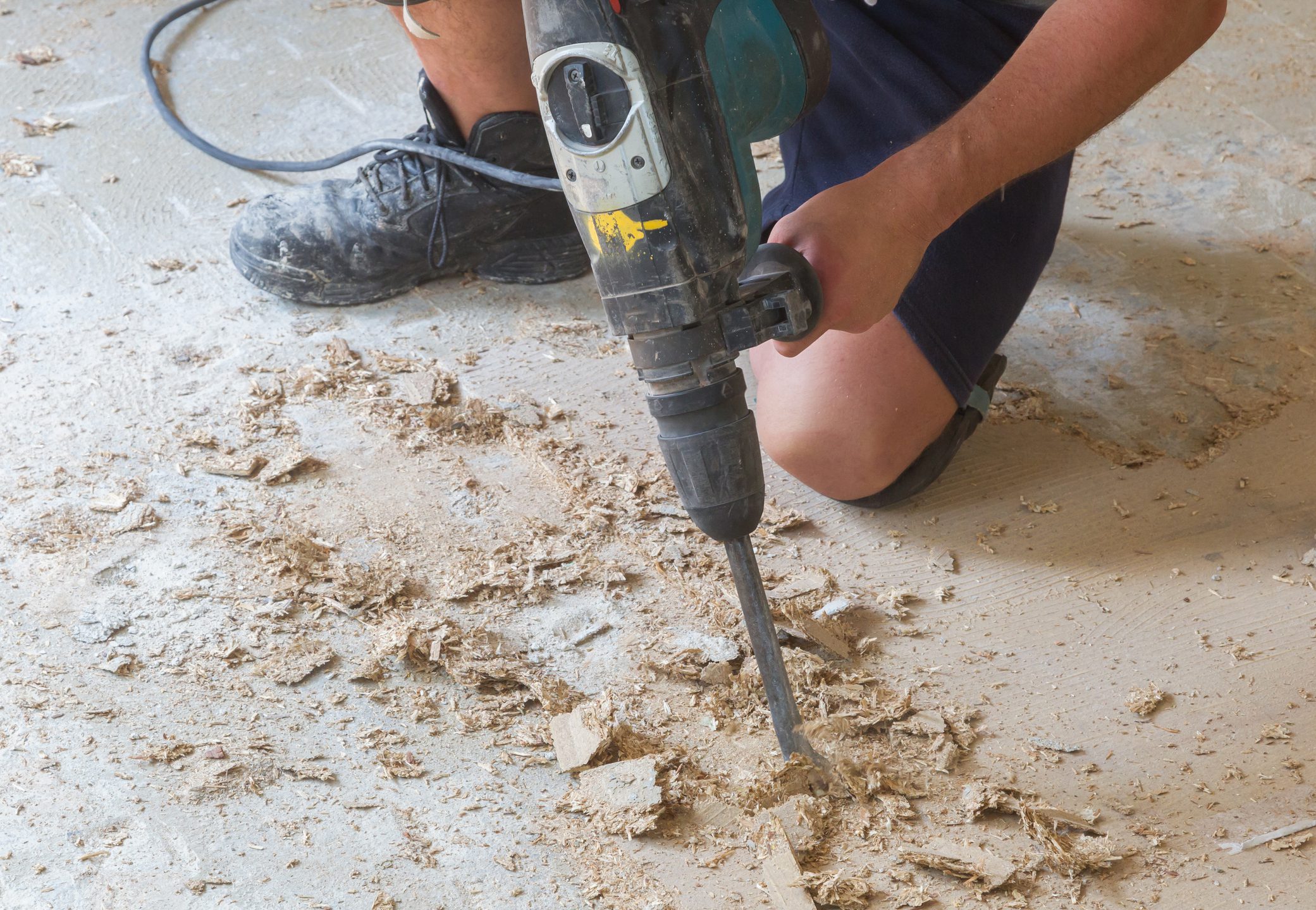Construction concept - Jackhammer, removing chipboard from the floor - Selective focus